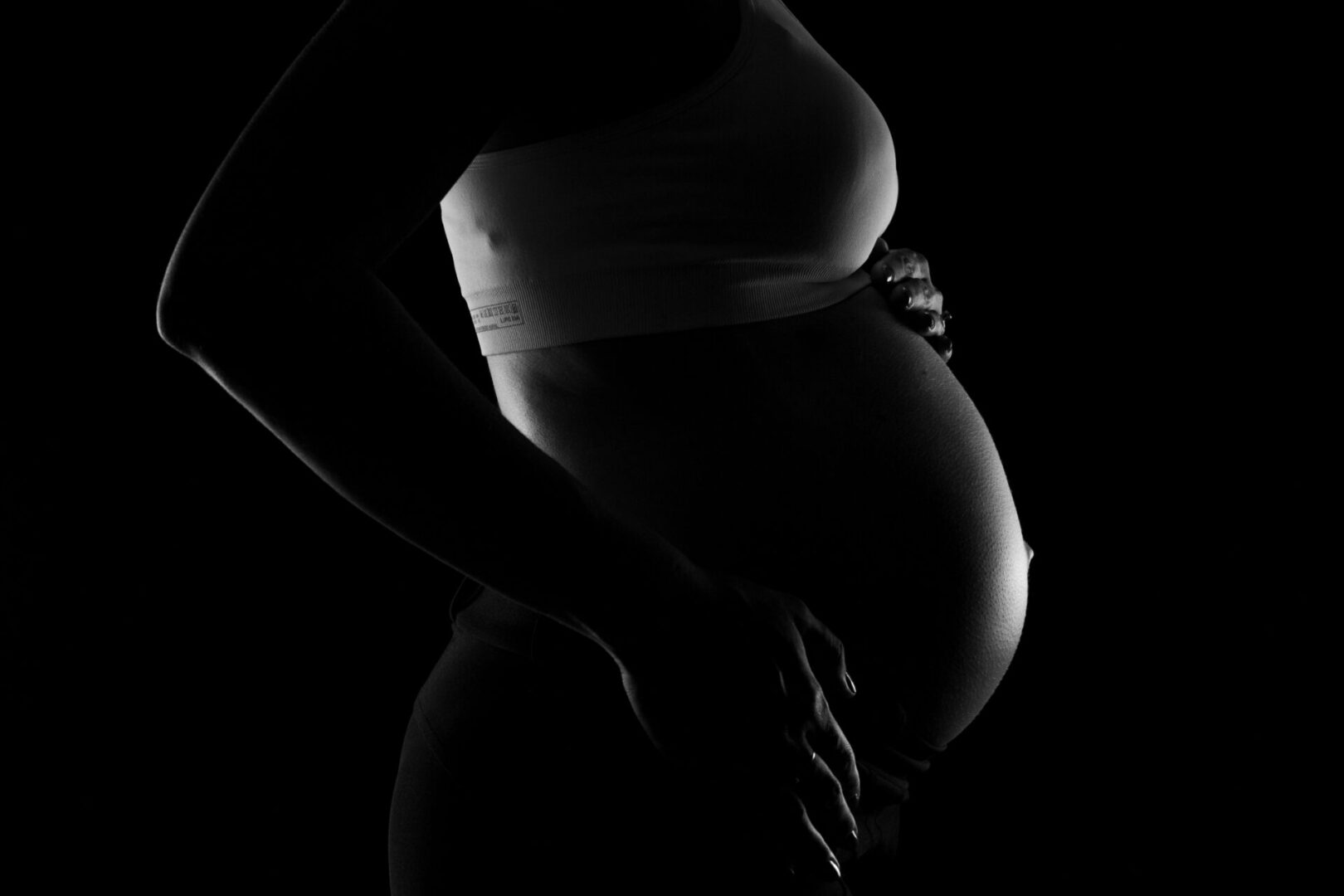 Black and white creative image of pregnant belly