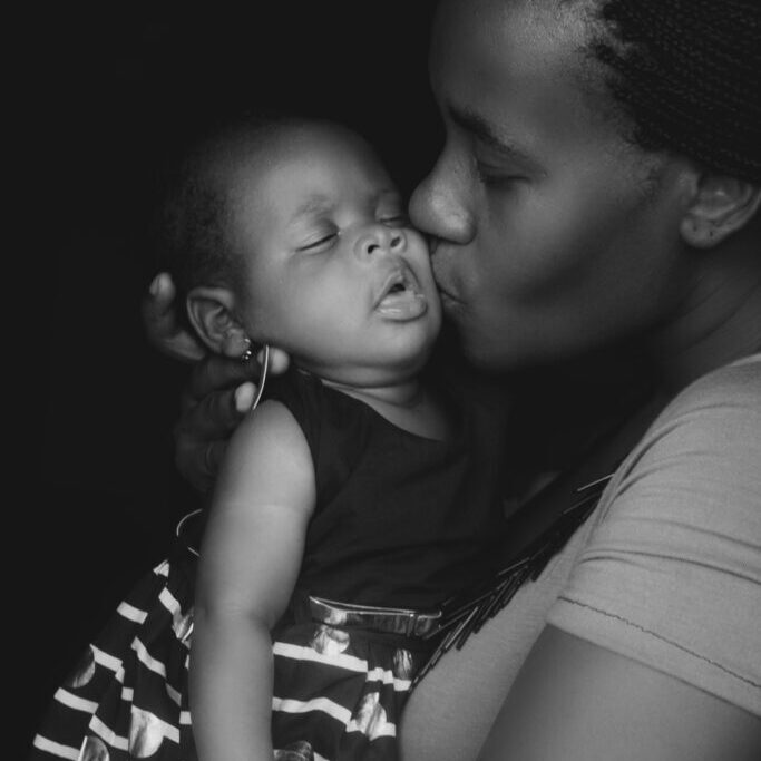 a woman kissing her baby girl